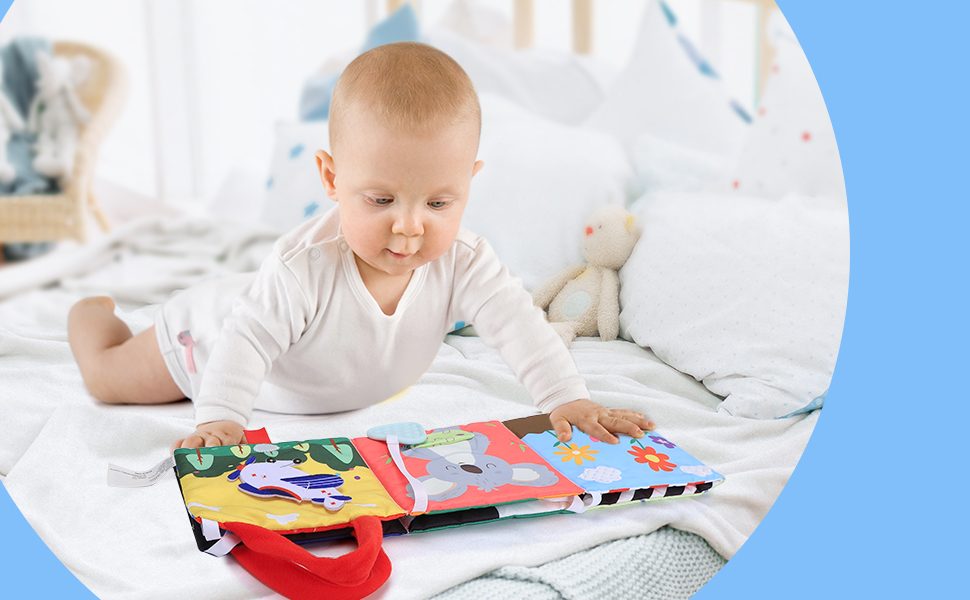 Baby reading a beiens cloth book on the play mat