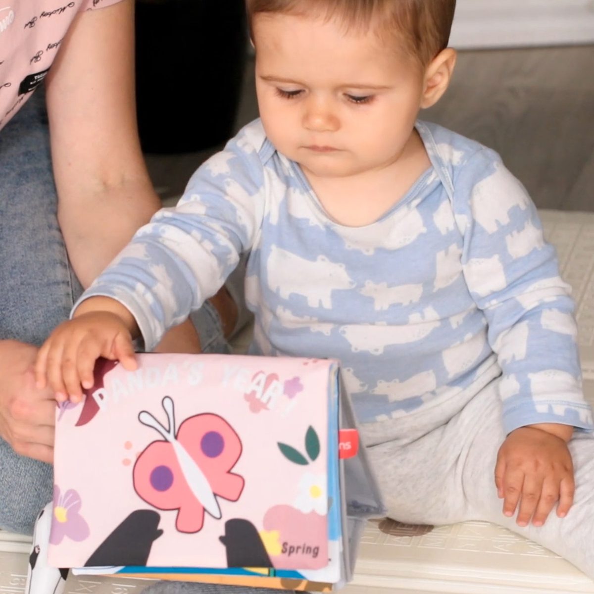 Toddler turning the pages of a beiens cloth book